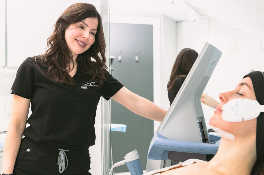 A member of our team in a black uniform smiles as she performs a treatment with Emface near Ocala